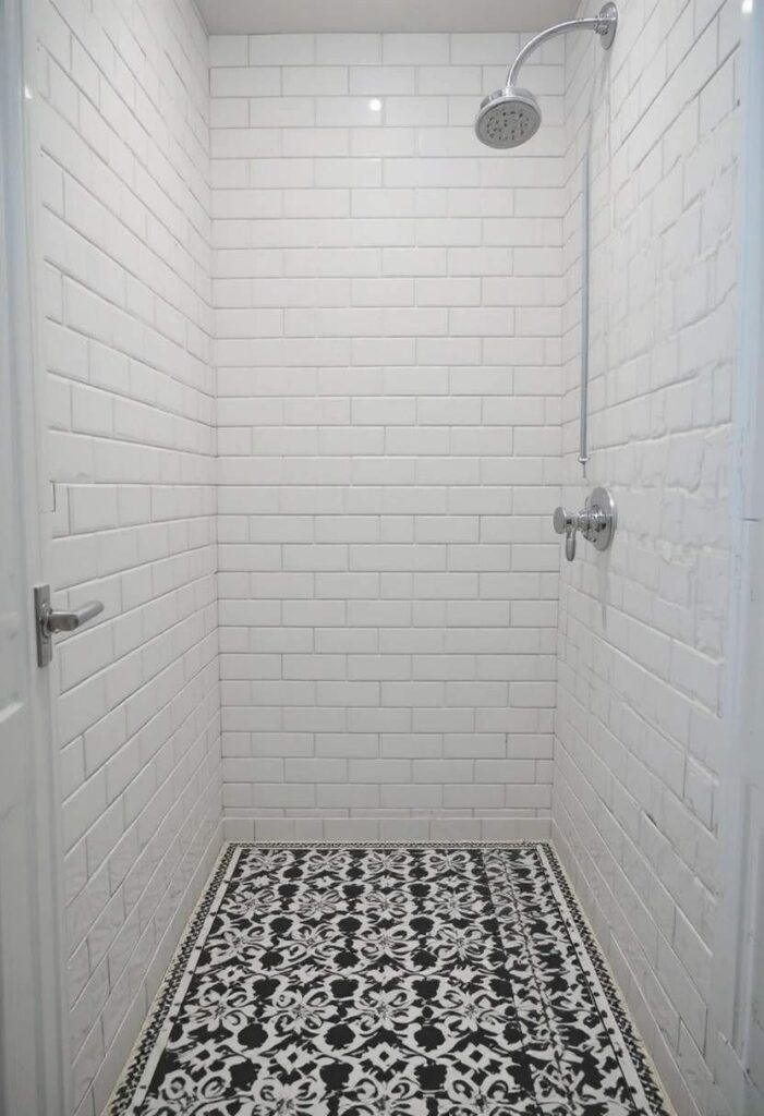 Bold patterned tile floor in small shower design